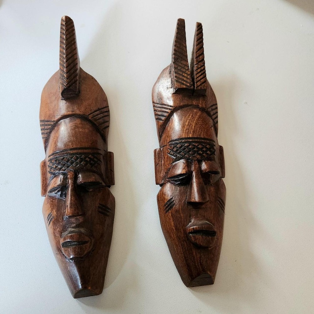 Set of 2 hand-carved wooden African tribal-style masks featuring elongated faces